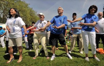 B.C. Premier Gordon Campbell (left) warms up with the crowd on Sunday, before the beginning of the 25th annual World Partnership Walk in Stanley Park. Photograph by Ward Perrin, Vancouver Sun