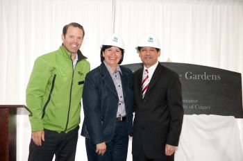 Yvonne Fritz and Nashir Samanani accept Habitat for Humanity hard hats from Andrew MacLachlan on behalf of the Government of Alberta and the Ismaili Muslim Community. The etched slate reading Golden Jubilee Gardens is in the background.