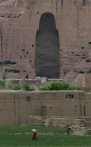 In this photo taken Wednesday, June 17, 2009, people walk past the cliffs that once held giant Buddhas destroyed by the Taliban in 2001 in Bamiyan, central Afghanistan. In an attempt to return one small part of the country to normalcy government officials and international donors are promoting tourism to attract visitors to the Bamiyan area. (AP Photo/Rahmat Gul)