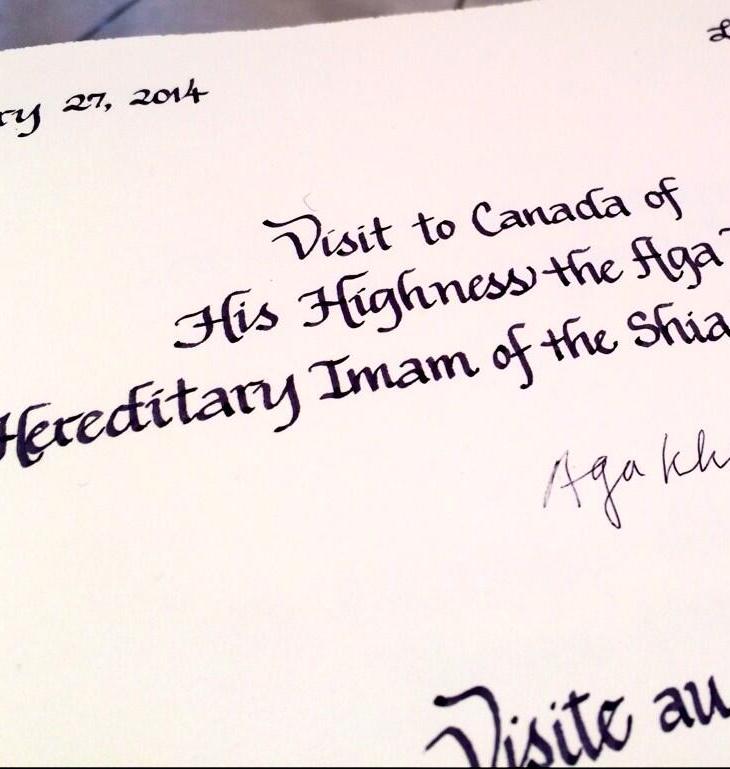 Aga Khan signs a book upon arriving at the House of Commons foyer