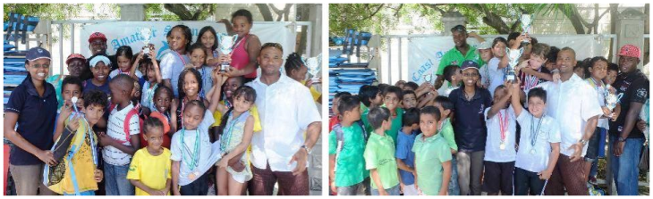  Coastweek -- Relationship Manager, Elsie Karanja of CfC Stanbic Bank awards trophies to the top three girls swimming team [left] and the top three boys swimming team [right]. The Aga Khan Academy took first place, Oshwal Academy Mombasa second and Dolphins Swim Club took third in the Open Junior Swimming Championship.