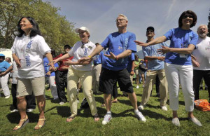 B.C. Premier Gordon Campbell (left) warms up with the crowd on Sunday, before the beginning of the 25th annual World Partnership Walk in Stanley Park. Photograph by Ward Perrin, Vancouver Sun 2009
