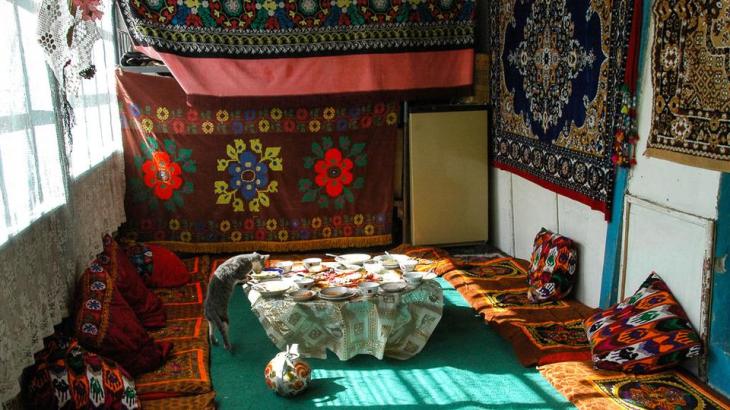 Breakfast time in a Pamiri home  There are no hotels in the tiny villages along the Wakhan Valley. Instead, travellers stay in local Pamiri homes, some of which can be found by consulting NGO-organized homestay networks such as Murghab Ecotourism Association or Pamirs Eco-Cultural Tourism Association. The traditional Pamiri house, called a huneuni chid, exhibits symbols of Shia Ismaili Islam, the sect followed by a majority of the Pamiri people. From the outside, their homes appear as simple timbered stone and plaster structures, but inside, they are warm and welcoming. At our homestay in Langar we were served a breakfast of homemade bread and milk tea.  Known for their hospitality for centuries, several Pamiri families invited us into their homes as we passed through their villages. We were repeatedly humbled by their offers to drink tea, even though the families had very little themselves. (Audrey Scott)