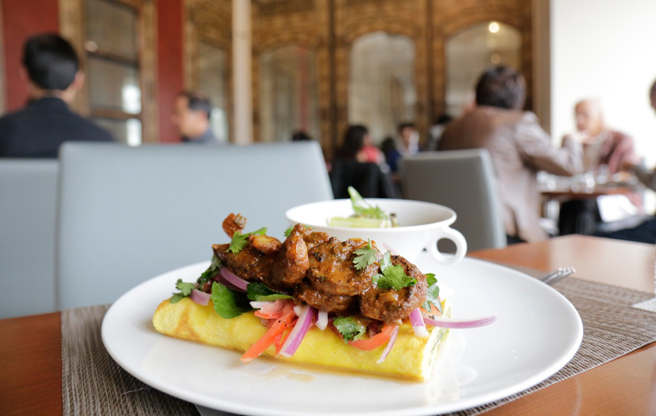 An open-faced prawn kati roll, with paratha-and-egg omelette, tamarind prawns, tomato and chopped onion ($16). (Image: Caroline Aksich)