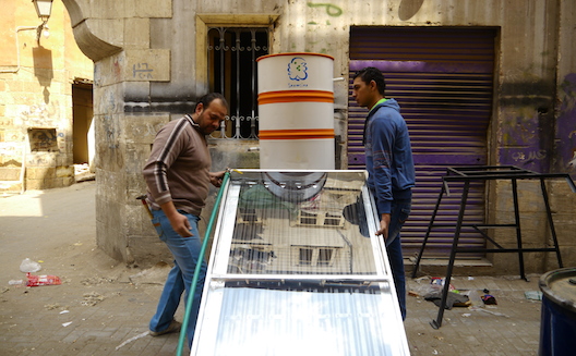 Ahmed Mahmoud and Mohamed Moustafa work on Shamsina’s solar water heater in Cairo’s Al Darb Al Ahmar slum. (Image; Rachel Williamson via Wamba)
