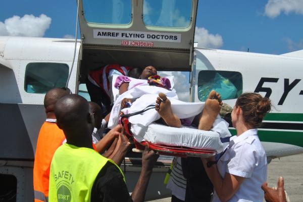 Medical personnel from AMREF Flying Doctors in Malindi carry Doris Mwangala onto a plane for Aga Khan University Hospital, Nairobi on Tuesday to undergo surgery to remove a brain tumour. (Image via The Star)
