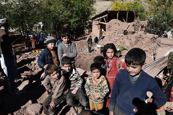 Pakistani earthquake survivor children gather in the midst of the rubble of destroyed homes in Charun Avir village, some 65 kilometers north of Chitral on October 29, 2015. Rescuers say they believe they have reached most of those affected by the powerful earthquake that ripped across Pakistan this week, but thousands of desperate survivors now face a race to rebuild with winter fast approaching. AFP PHOTO / Farooq NAEEM