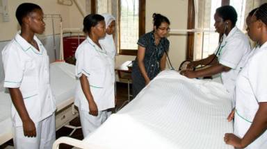Aga Khan University students from the Tanzania campus practice their medical skills on a dummy as part of their nursing training. Photo: Maureen Vaught/Rotary News