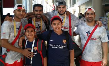 Riyaan (front left) is seen pictured with his older brother Qayl after Team USA Blue players (l to r) Adnan Dahlvani, Zohib Hadi, Naushad Lalani and Irfan Charania autographed his cap. (Image Credit ASJM)