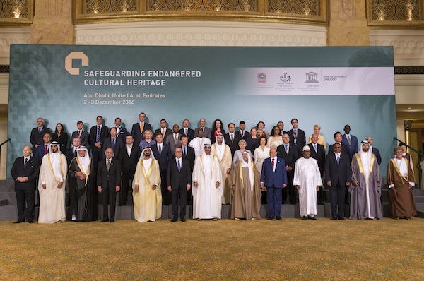 In this Saturday Dec. 3, 2016 photo released by Emirates News Agency, WAM, French President Francois Hollande, 6th down left, poses for a photo between Sheikh Mohammed bin Zayed al-Nahyan, Crown Prince of Abu Dhabi and UAE's deputy commander-in-chief of the armed forces, on his right, and Sheikh Mohammed bin Rashid al-Maktoum, UAE prime minister and ruler of Dubai with the other head of states and dignitaries during the Safeguarding Endangered Cultural Heritage Conference at Emirates Palace in Abu Dhabi, United Arab Emirates. (Emirates News Agency via AP)