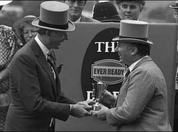 His Highness Prince Karim Aga Khan IV (R) receives the Derby trophy after his horse Kayhasi won the race in Epsom in 1988. Image credit: Reuters